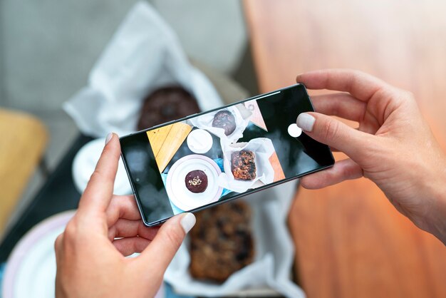 Mãos segurando fotos de sobremesa de perto