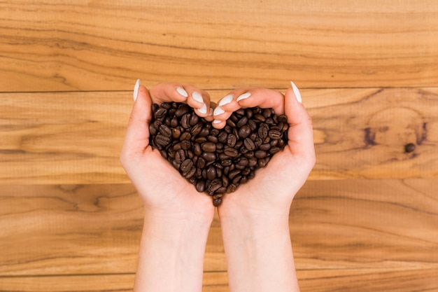 Mãos segurando grãos de café