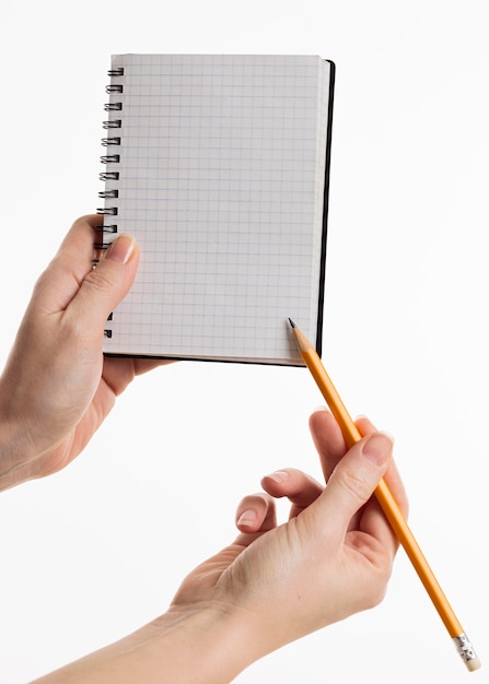 Foto grátis mãos segurando um caderno com lápis