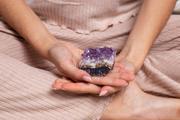 Foto grátis mãos segurando um cristal roxo