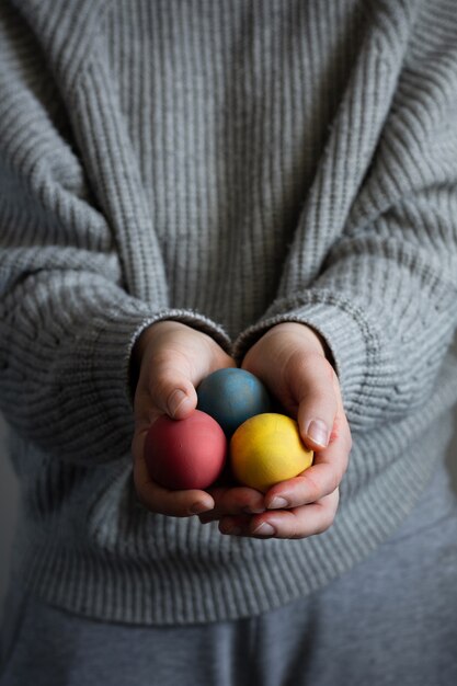 Mãos segurando um monte de ovos de Páscoa coloridos