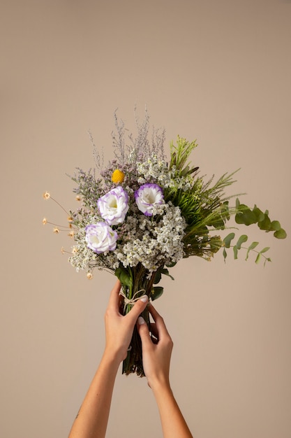 Mãos segurando uma bela variedade de flores boho