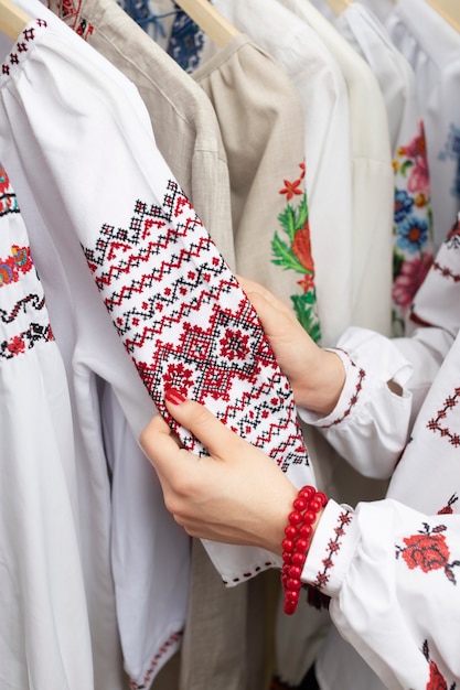 Mãos segurando uma camisa bordada tradicional