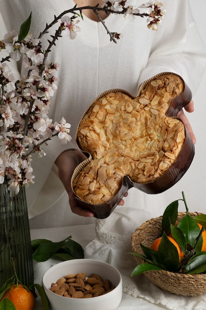 Foto grátis mãos segurando uma deliciosa colomba alto ângulo