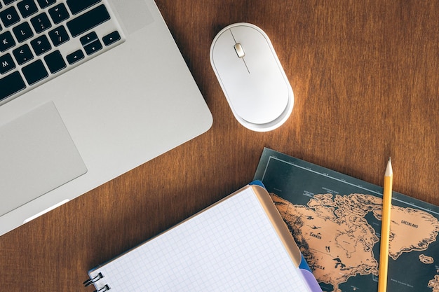 Foto grátis mapa do mundo de laptop e caderno em uma mesa de madeira