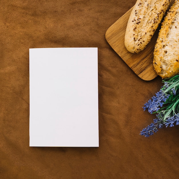 Foto grátis maquete de livro com pão e flor