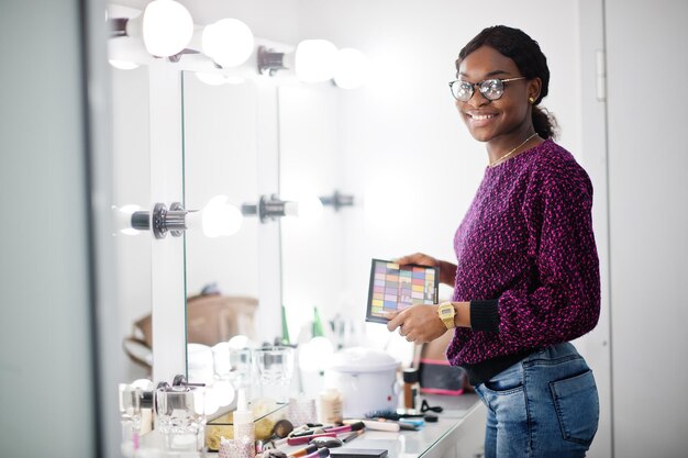 Maquiador de mulher afro-americana no salão de beleza