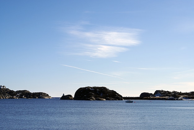 Mar azul em Stavern, Noruega, com pedras ao fundo