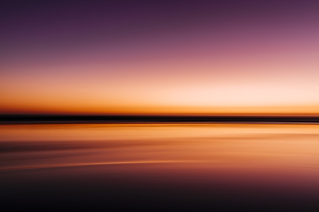 Mar durante um pôr do sol colorido com uma longa exposição