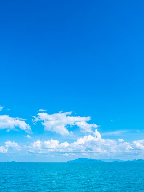 Mar e oceano bonitos na nuvem branca e no céu azul