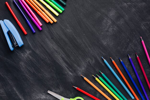 Marcadores coloridos e lápis em fundo cinza