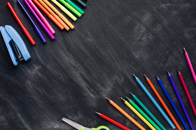 Marcadores coloridos e lápis em fundo cinza
