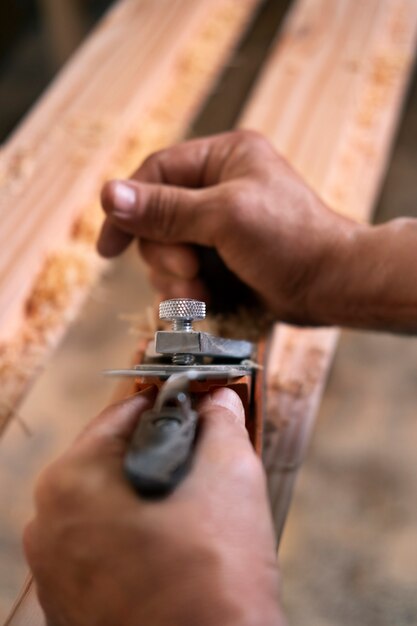 Marceneiro masculino em sua loja trabalhando com ferramentas e equipamentos