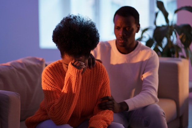 Marido africano consolando esposa triste e chorando depois de briga em casa tentando salvar relacionamento