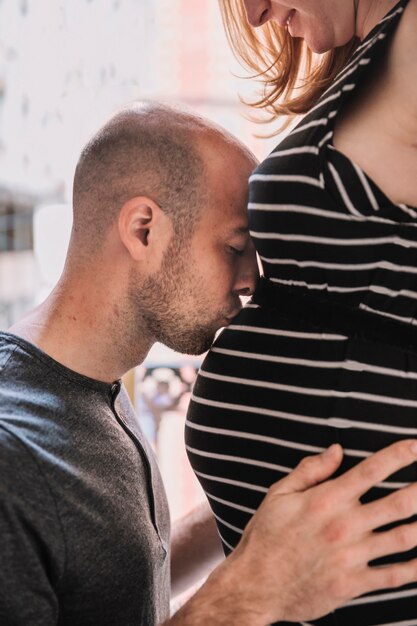 Marido beijando mulher grávida