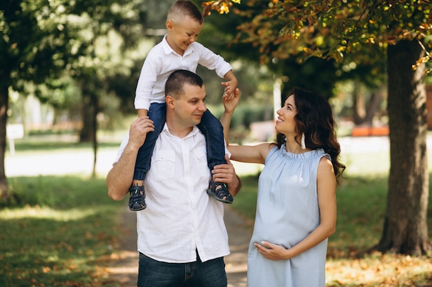 Marido com a esposa grávida e seu filho no parque