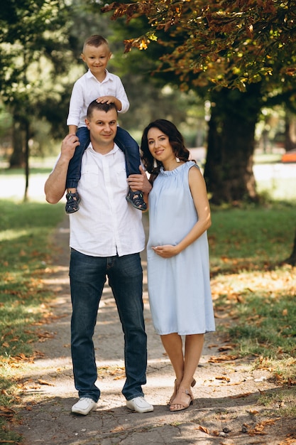 Marido com a esposa grávida e seu filho no parque