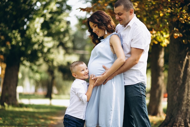 Marido com a esposa grávida e seu filho no parque