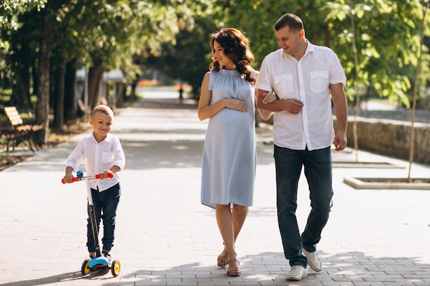 Marido com a esposa grávida e seu filho no parque