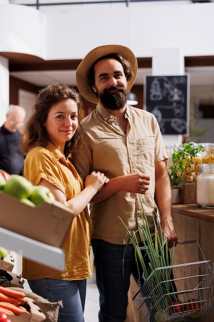 Foto grátis marido e mulher fazem compras em uma loja com desperdício zero, em busca de produtos saudáveis a granel de origem local. casal de vida verde comprando produtos básicos de despensa na loja do bairro local