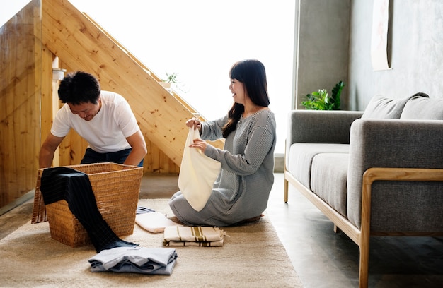 Marido e mulher japoneses dobrando roupas juntos