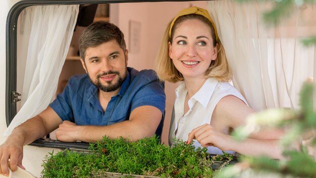 Marido e mulher olhando pela janela de uma caravana