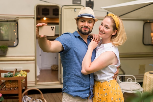 Marido e mulher tirando uma selfie enquanto se abraçam