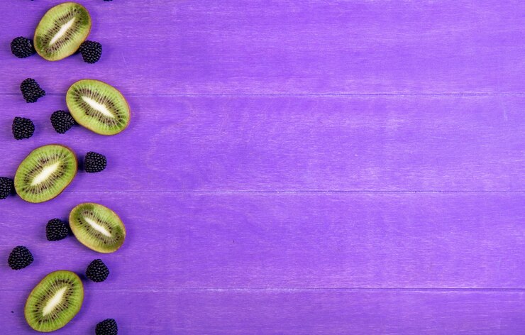 Foto grátis marmelada de espaço de cópia de vista superior sob a forma de uma amora com fatias de kiwi em um fundo roxo