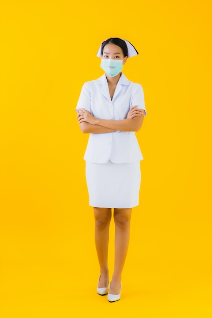 Máscara asiática bonita do desgaste da enfermeira da mulher asiática bonita do retrato para proteger covid19 ou coronavirus
