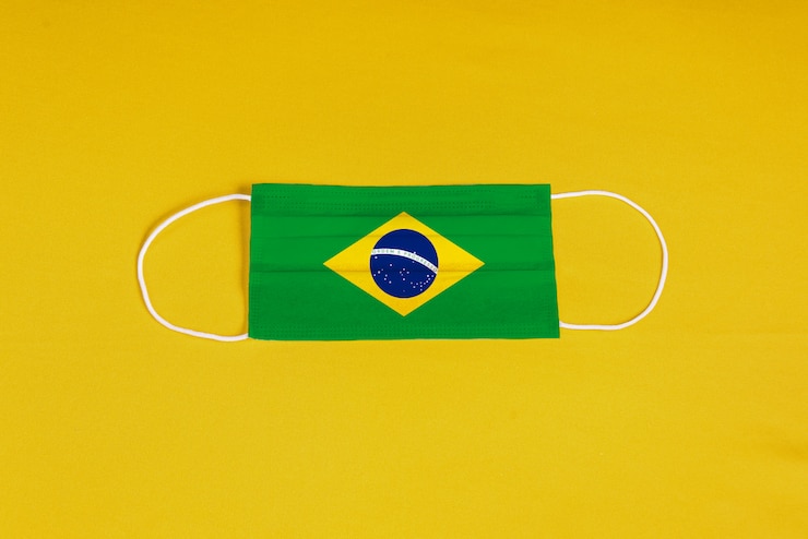 Foto grátis máscara cirúrgica em fundo amarelo com bandeira do brasil