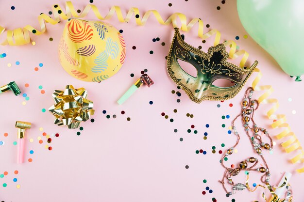 Máscara de carnaval de máscaras de ouro com decorações de festa em pano de fundo-de-rosa