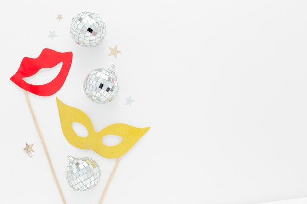 Máscara de festa com globos de prata na mesa
