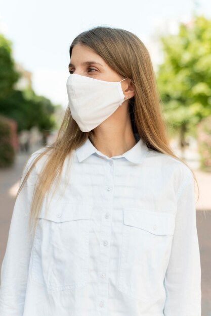 Foto grátis máscara vestindo ao ar livre da mulher
