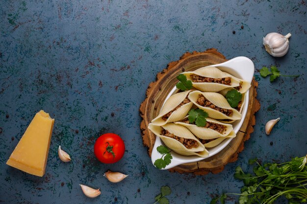 Massa italiana Conchiglioni Rigati recheada com carne.