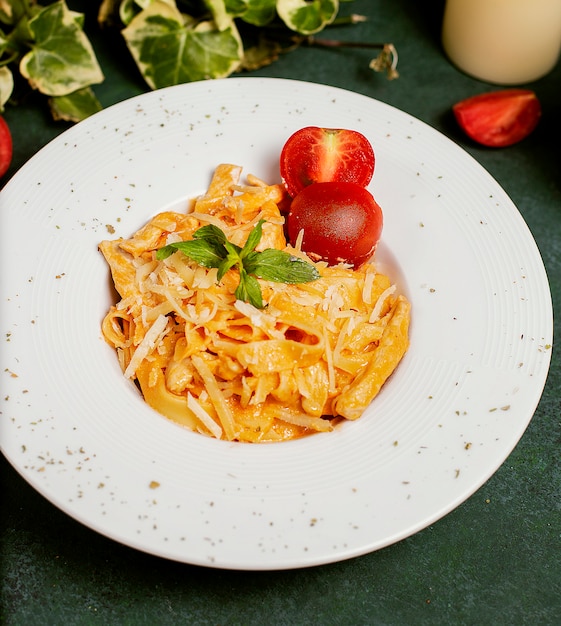 Foto grátis massa no molho de tomate com parmesão, tomate e basilic desbastados.