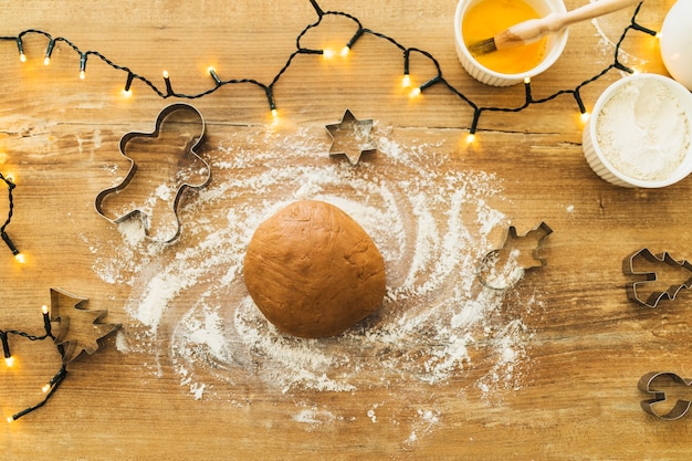 Foto grátis massa perto de formulários para biscoitos e luzes de fada