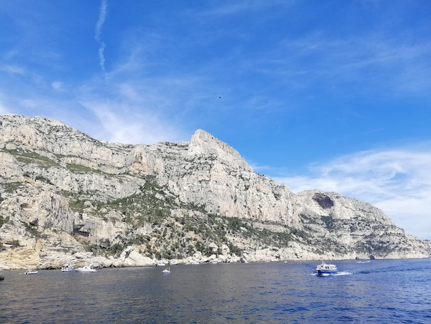 Massif des Calanques cercado pelo mar sob um céu azul e luz do sol na França