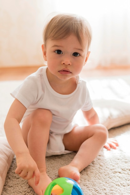 Foto grátis meados de tiro bebê fofo e brinquedo