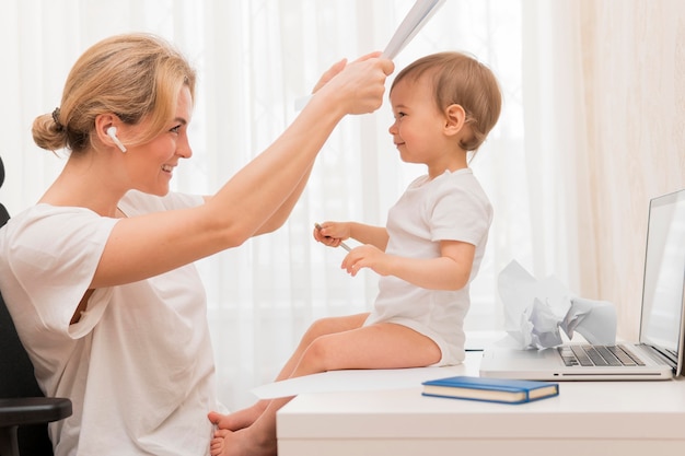 Meados de tiro mãe jogando espreitar uma vaia com bebê