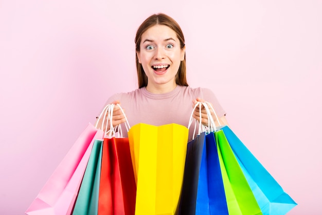 Meados de tiro mulher feliz segurando sacos e olhando para a câmera