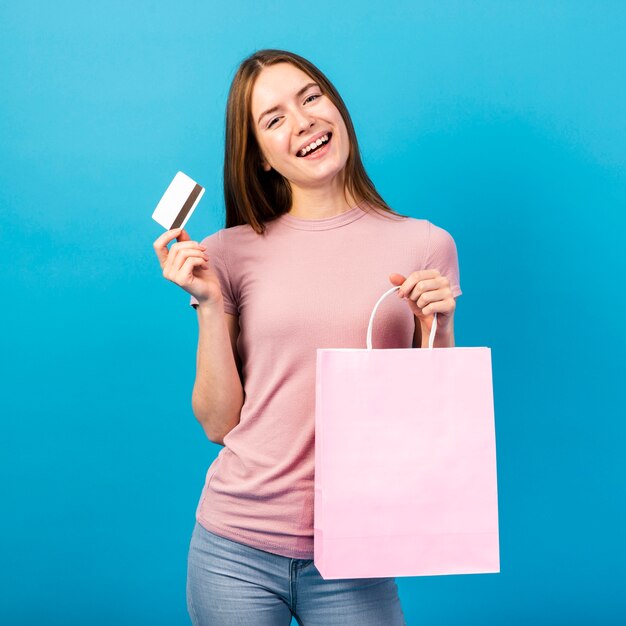 Meados de tiro mulher segurando o cartão de crédito e bolsa