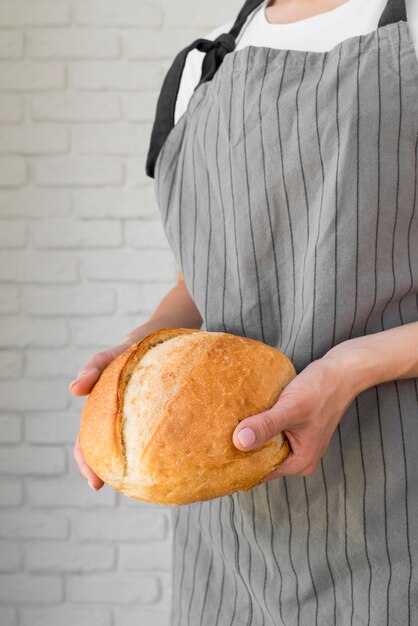 Meados de tiro mulher segurando pão fresco