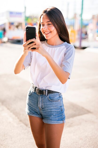 Meados de tiro mulher tirando foto com telefone