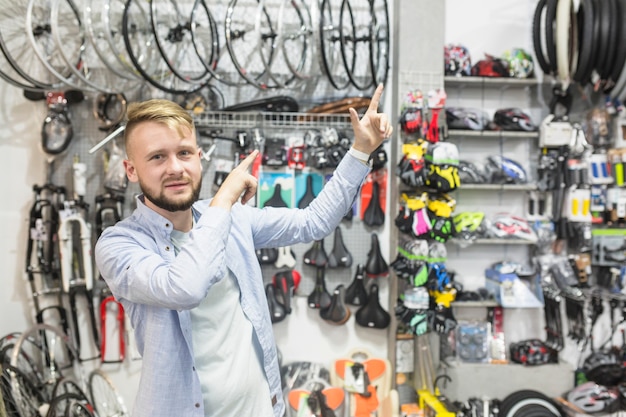 Mecânico de bicicleta apontando para cima na oficina