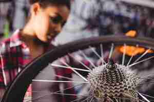 Foto grátis mecânico examinando uma roda de bicicleta