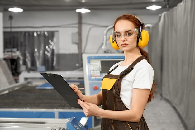 Foto grátis mecânico feminino em fones de ouvido uniformes e protetores