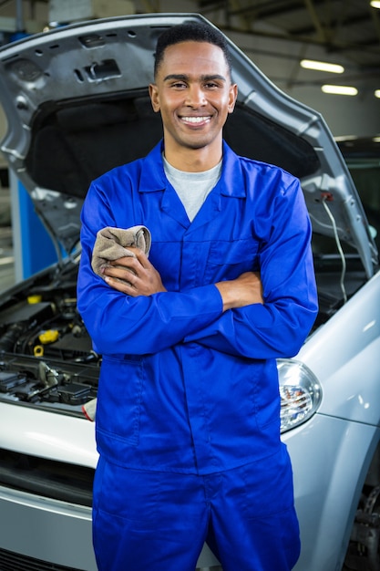 Foto grátis mecânico que está feliz na garagem de reparação