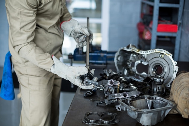 Mecânico que verific um carro peças