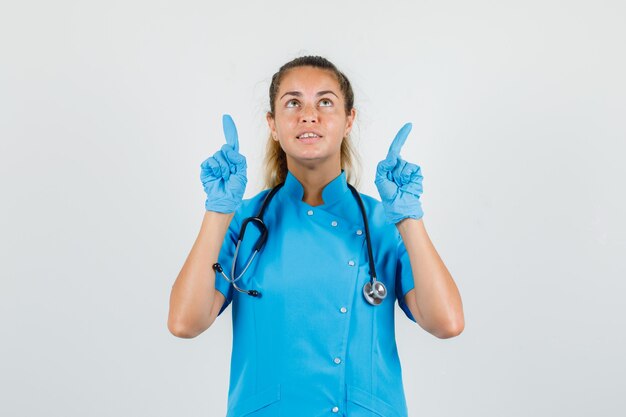 Foto grátis médica apontando para os dedos em uniforme azul