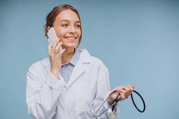 Médica com jaleco falando ao telefone